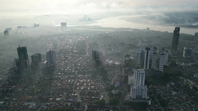 A city with a river in the background. The sky is hazy and the buildings are tall. Aerial view Larkin, Johor