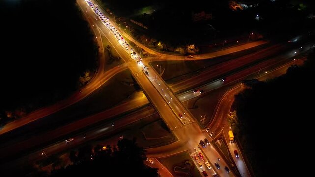 A busy highway with a lot of traffic. The highway is lit up at night. There are many cars on the road. Aerial night view Larkin