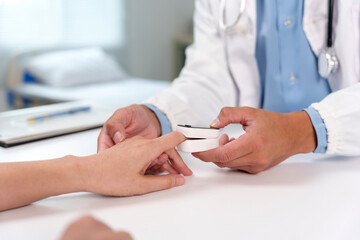 Doctor examining patient's oxygen levels and pulse rate using a pulse oximeter in a clinic, providing healthcare