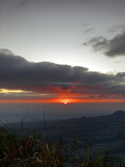 Obraz premium Sunrise over misty mountain landscape with dramatic clouds