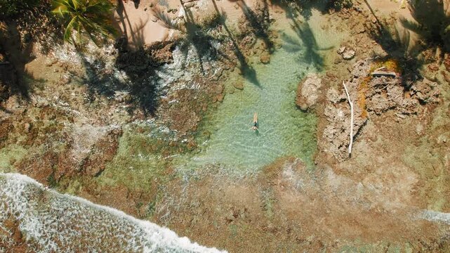 Woman floating in a calm tide pool on the Costa Rica Caribbean coast