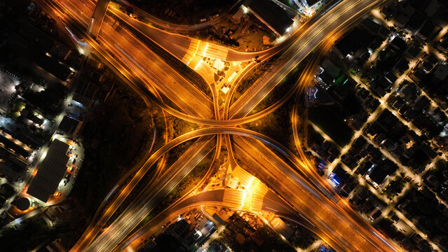 Aerial drone slow shutter night shot of illuminated highway multilevel junction in shape of butterfly, a modern, scalable, and practical approach to managing Intelligent Transportation systems
