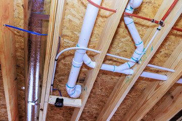 Pipes and ducts installed in ceiling of construction site plumbing and HVAC systems in progress