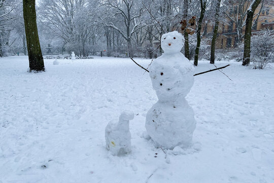 Classic Snowman and Snowdog in Berlin Kreuzberg on a snowy winter day at Grimmstrasse park. 