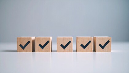 Five wooden blocks arranged in a clean horizontal line on a white surface with a light blue background, each marked with a bold black checkmark&mdash;symbolizing task completion, approval, and goal achievem