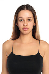 Fototapeta premium Studio shot of a natural woman with long dark hair wearing a black top, neutral expression, portrait on a white background