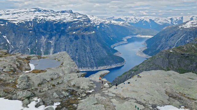 Panoramic view of Ringedalsvatnet fjord from Trolltunga hiking area in Norway. Dramatic cliffs and deep blue water emphasize iconic Nordic scenery.
