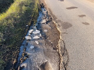 The road is all broken up from frost heave and traffic. Now there's ice frozen in all the potholes.