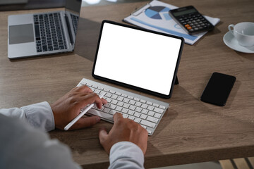 man working plan in front of digital tablet, working on laptop computer at home office Working from home