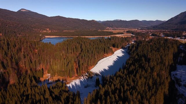 Aerial view of a natural ice rink at Grubsee, Bavaria. Drone footage capturing people playing hockey and skating in the heart of the snowy Alps with the Karwendel mountains in sight