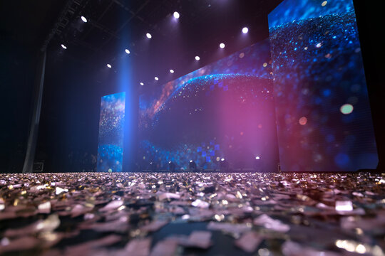 Colorful lights and confetti cover the stage at an exciting event showcasing vibrant visual displays