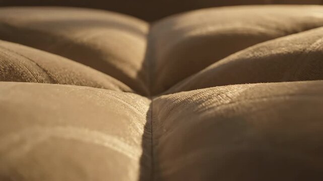 Abstract cinematic close-up showcasing the intersecting geometric folds and subtle pattern lines of two plush beige sofa cushions softness, visual texture, design