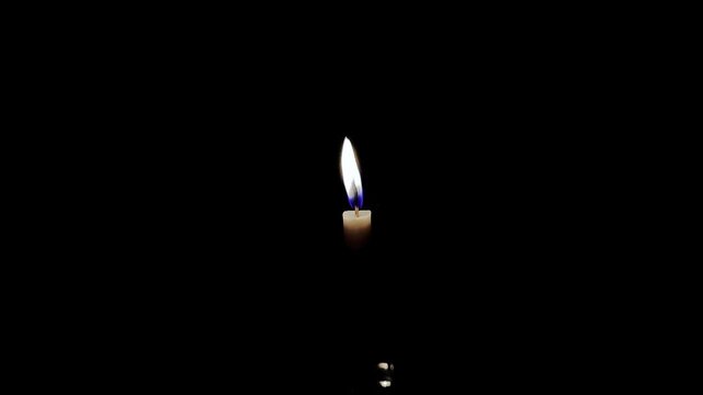 Illuminated Candle: A solitary candle flame dances brightly against a backdrop of deep darkness, representing hope, peace, and spirituality.