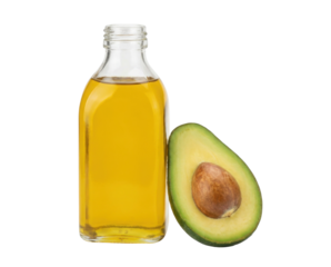 A bottle of golden avocado oil beside a sliced avocado, showcasing its vibrant green flesh and brown seed.