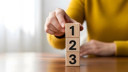 Person stacking wooden blocks with numbers one two and three