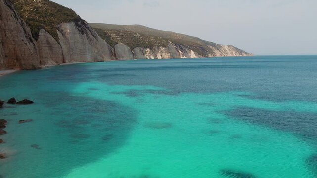Turquoise water and high cliffs along remote Kefalonia beach in Greece