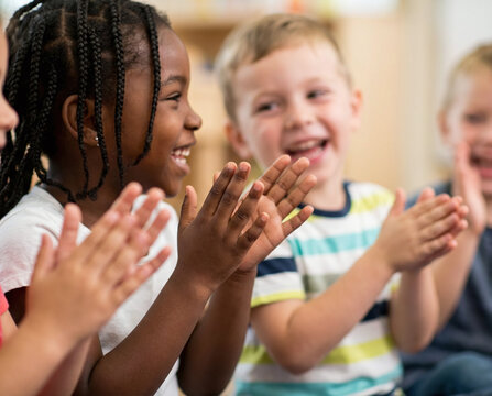 Children clapping hands together, expressing joy, excitement and shared happiness during a playful moment.