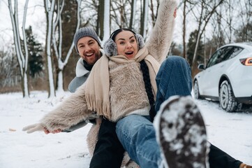Obraz premium Happy couple enjoying winter fun in snowy landscape, laughing and playing together, showcasing joy and connection in a beautiful outdoor setting