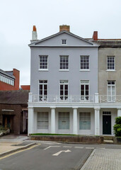 A three-story building with a balcony and columns.