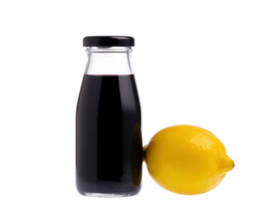 A glass bottle filled with dark liquid sits next to a bright yellow lemon, showcasing a vibrant contrast.