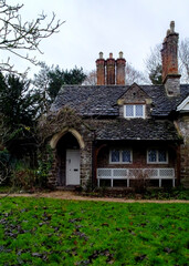A stone cottage with a white door and a bench in front of it.
