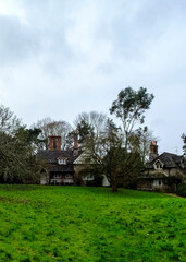 A view of a house with a green lawn and trees.