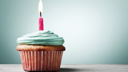 cupcake. A solitary birthday cupcake topped with frosting and a candle, set against a soft pastel backdrop. symbolizing life milestones and joyful moments.