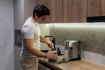 Caucasian man pouring ground coffee into a portafilter
