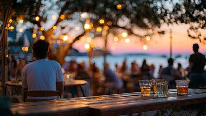 Outdoor restaurant scene with blurred figures, string lights, and drinks at dusk