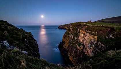 A coastal landscape at dusk, featuring a full moon reflected on the calm sea. Rugged cliffs frame the water