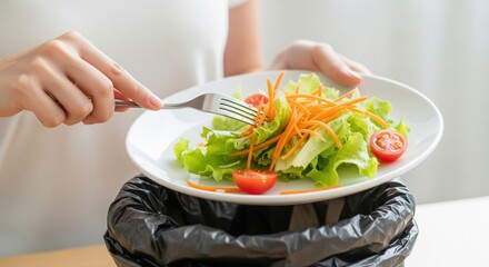 Woman Discards Fresh Salad into Trash Bin, Highlighting Food Waste