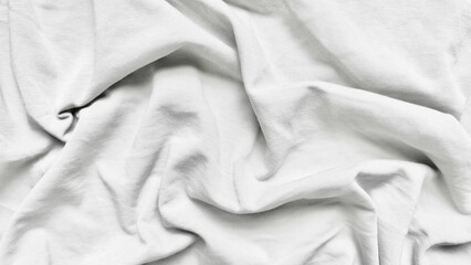 elegantly draped white cotton fabric wrinkles unfolding in soft minimalist closeup for clean design...