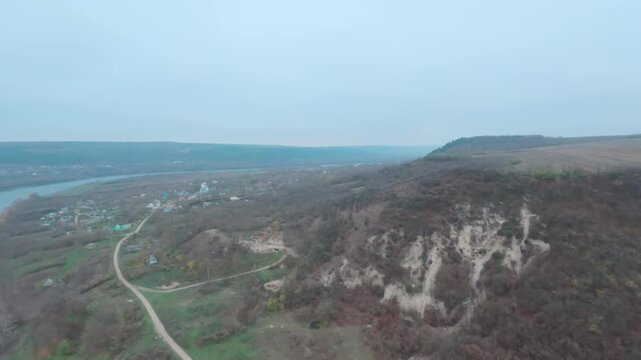 FPV drone Aerial shot flying. Beautiful mountain view of nature landscape an old village and the Dniester river in late autumn. Moldova, Europe.