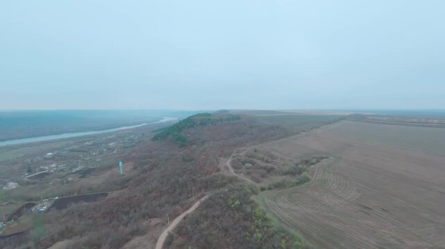 FPV drone Aerial shot flying. Beautiful mountain view of nature landscape an old village and the Dniester river in late autumn. Moldova, Europe.