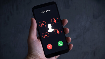 Smartphone shows unknown incoming call with warning signs, representing scam, fraud, spam, and cybersecurity risk.