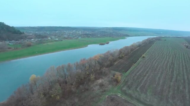 FPV drone Aerial shot flying. Beautiful  view of nature landscape of the Dniester River and old village in late autumn. Moldova, Europe.