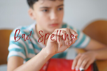 BAD SPELLING. Childhood, pre-adolescence, and adolescence. Preteen boy writing the text on the screen with a red marker