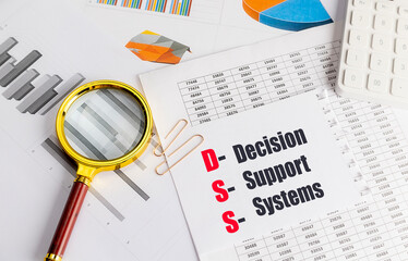 Paper with text dss decision support systems on business charts with magnifying glass and calculator