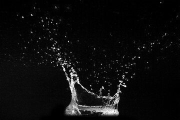 A dramatic water splash with droplets suspended against a dark backdrop
