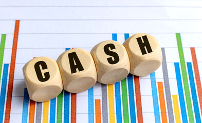 Wooden cubes with text cash on colorful bar chart background