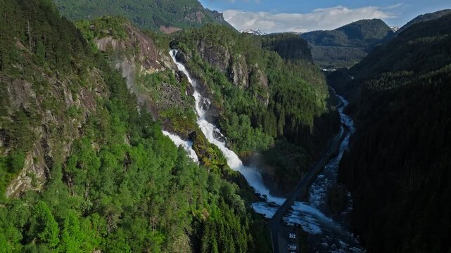 Long cascading view of Latefossen waterfall in Norway. Scenic aerial footage capturing the iconic twin falls and untouched Nordic nature in summer.