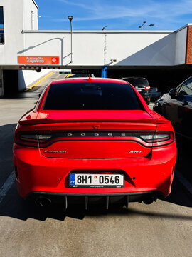 Red Dodge Charger SRT parked in a parking garage near mall entrance