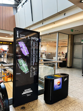 Information Galerie Vankovka board and directory map inside a bustling shopping mall with storefronts and shoppers