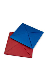 Red and blue square for two players in Ddakji on white background. Vertical photo of two player game from South Korea. Fold colored sheets of paper to create squares for game