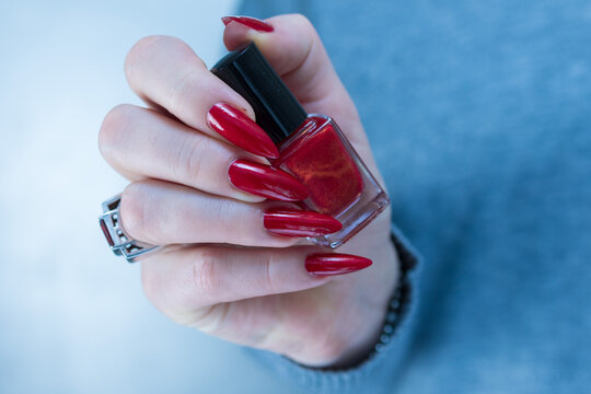 Female hand with long nails and a bright red manicure