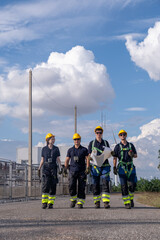 Workers walk together on a path at a construction site during the day in a clear sky with some clouds