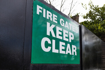 Fire Gates Keep Clear Green Safety Sign on Black Metal Fence