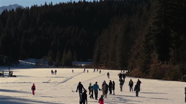 Lake Grubsee, Garmisch-Partenkirchen district, Upper Bavaria, Germany. Sonniger Wintertag am Grubsee in Bayern. Menschen geniessen Eislaufen auf dem gefrorenen See. Wettersteingebirge und Karwendel
