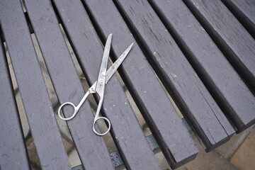 Old metal scissors tool top view wooden background