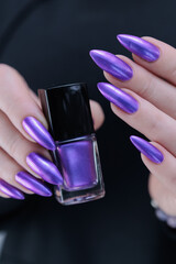 Woman hand with long nails and a bridht purple nail polish